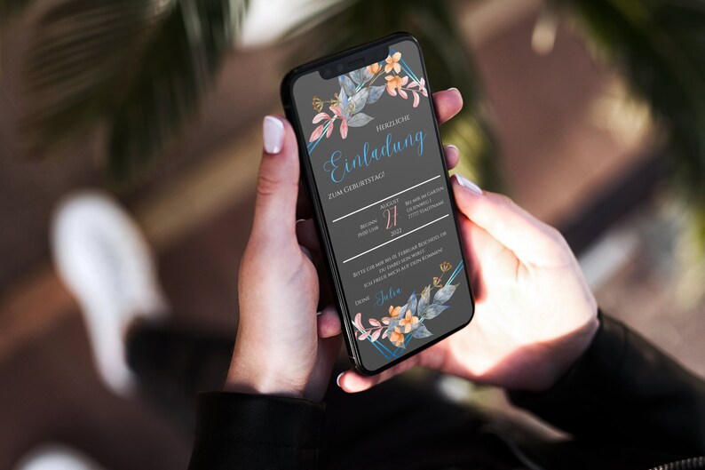 May include: A smartphone displaying a digital invitation with a floral design. The invitation reads "Herzliche Einladung zum Geburtstag" and includes the date "August 27, 2023".