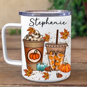 May include: White tumbler with a black handle and a personalised name "Stephanie". The tumbler features a fall-themed design with two coffee drinks, one with whipped cream and the other with pumpkin spice, surrounded by autumn leaves and pumpkins.