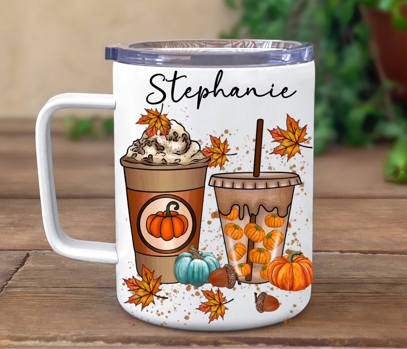 May include: White tumbler with a black handle and a personalised name "Stephanie". The tumbler features a fall-themed design with two coffee drinks, one with whipped cream and the other with pumpkin spice, surrounded by autumn leaves and pumpkins.