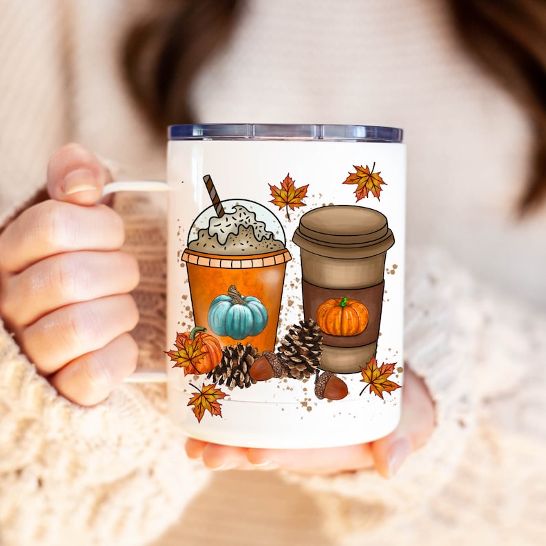 May include: White ceramic mug with a fall-themed design featuring two coffee cups with whipped cream and pumpkins, surrounded by autumn leaves and acorns.