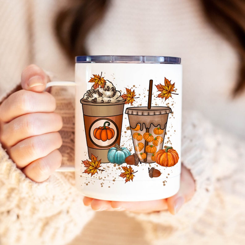 May include: White stainless steel tumbler with a fall-themed design. The tumbler features two cups of coffee with whipped cream and pumpkin spice, surrounded by autumn leaves and pumpkins.