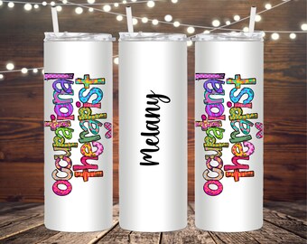 May include: White insulated tumbler with a straw. The tumbler features the text "Occupational Therapist" in colorful, patterned letters. The name "Melany" is written in black script on the center tumbler.
