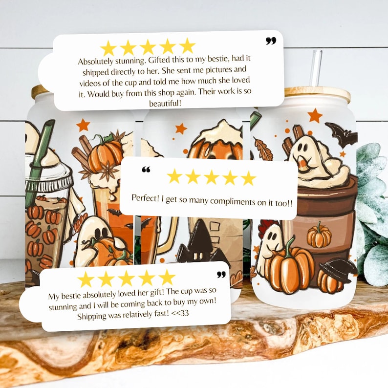 May include: Two white ceramic tumblers with a fall-themed design featuring pumpkins, ghosts, bats, and coffee cups. The tumblers have a straw and a wooden lid. The tumblers are on a wooden surface. The text on the image reads: "Absolutely stunning. Gifted this to my bestie, had it shipped directly to her. She sent me pictures and videos of the cup and told me how much she loved it. Would buy from this shop again. Their work is so beautiful!" and "Perfect! I get so many compliments on it too!!" and "My bestie absolutely loved her gift! The cup was so stunning and I will be coming back to buy my own! Shipping was relatively fast! <33"