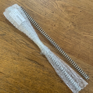 May include: Two silver metal springs, one wrapped in clear plastic bubble wrap, with a white label that reads "Ref: 8573947298,  Made in China".
