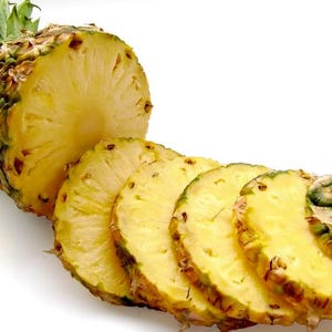 Könnte beinhalten: Teilweise geschnittene Ananas mit mehreren goldgelben Scheiben. Die Ananas hat einen grünen Blattschopf und eine raue, strukturierte Außenseite. Die Scheiben sind in einer Reihe angeordnet und zeigen das saftige Innere der Frucht.