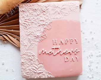 May include: Pink square silicone stamp with a floral design and the text "Happy Mother's Day" in white.