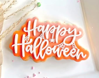 May include: Orange and white decorated sugar cookie with the words "Happy Halloween" in white icing.