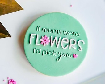 May include: A green round cookie with white icing and the text "If mums were flowers I'd pick you" with a pink flower and heart.