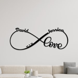 Peut inclure: Décoration murale en métal noir en forme de symbole d'infini avec les noms "David" et "Jessica" et la date "12.7.19" inscrits à l'intérieur du symbole. Le mot "Love" est écrit dans une police stylisée sous le symbole.