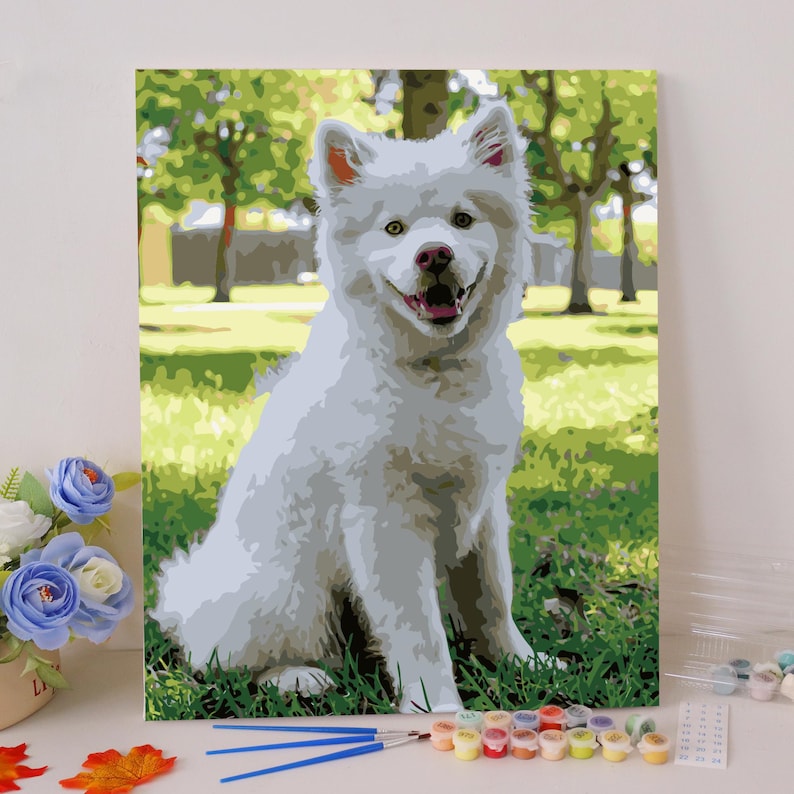 Pode incluir: Um c&atilde;o branco e felpudo com olhos castanhos est&aacute; sentado em um parque gramado. O c&atilde;o est&aacute; olhando diretamente para a c&acirc;mera e tem a l&iacute;ngua ligeiramente para fora. O c&atilde;o est&aacute; cercado por grama verde e &aacute;rvores.