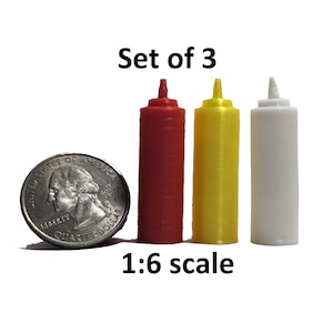 May include: Set of three miniature condiment bottles in red, yellow, and white. The bottles are 1:6 scale and are shown next to a US quarter for size comparison.