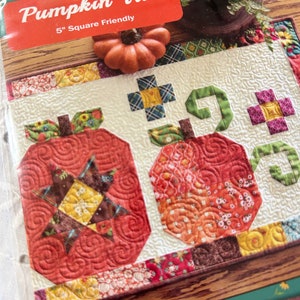 Puede incluir: Patrón de colcha Pumpkin Trio con tres diseños de calabaza de estilo patchwork. El patrón es compatible con cuadrados de 5 pulgadas.