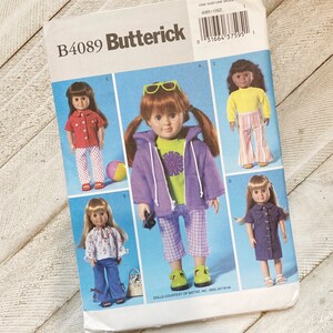 May include: A Butterick sewing pattern, B4089, featuring doll clothing designs. The cover displays various doll outfits, including a red shirt with polka-dot pants, a purple hoodie, and a denim dress. The pattern includes the text "ONE SIZE/UNE SEULE TAILLE".