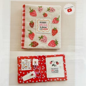 Może przedstawiać: Ręcznie robiona książka na igły z motywem truskawek. Okładka zdobiona haftowanymi truskawkami i napisem "Every stitch is done with LOVE". W środku ilustracje związane z szyciem i napis "Add a whole lot of LOVE to everything You Create."