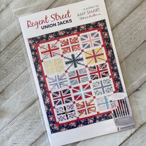 May include: A quilt pattern booklet titled Regent Street Union Jacks by Amy Smart. The cover features a quilt design with twelve Union Jack blocks in various floral and polka dot fabrics, surrounded by a dark blue floral border and a white background.