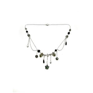 以下が含まれることがあります： ぶら下がっているチャームが付いたシルバーカラーのネックレス。ネックレスは、黒と虹色の緑色のビーズ、小さな星、涙型のペンダントなど、さまざまなチャームが付いた繊細なチェーンが特徴です。デザインは対称的です。