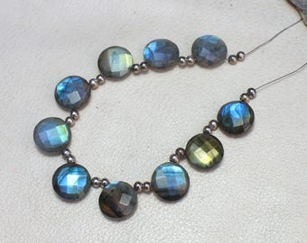 May include: Two strands of faceted, round labradorite beads. The beads display a mix of blues, greens, and grays, with iridescent flashes. The beads are strung on a thin, silver-colored wire, and are suitable for jewelry making.