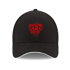 May include: Black baseball cap with a curved brim and a white trim. The cap features a red graphic of the letters "REN" with a dripping blood effect. The cap is a classic six-panel design.