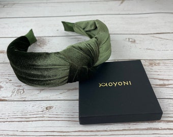 May include: A dark green velvet knotted headband with a black box that says "XOYONI" in gold lettering.