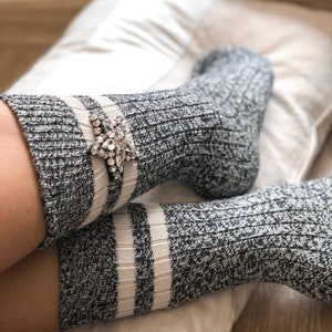 May include: A pair of gray and white striped socks with a sparkly star-shaped embellishment on one sock.