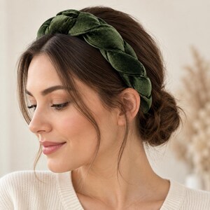 Side view of a woman wearing a dark green velvet braided headband, showing the wide plaited design with an elegant low bun hairstyle