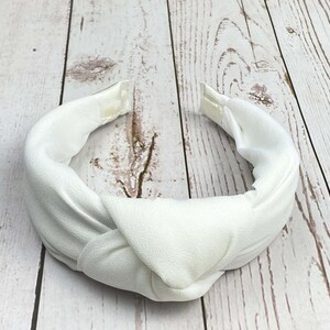 An elegant Snow White padded headband, featuring a chic design perfect for weddings and celebrations. The sophisticated hair accessory is made from high-quality materials, offering a touch of class and comfort for any occasion.