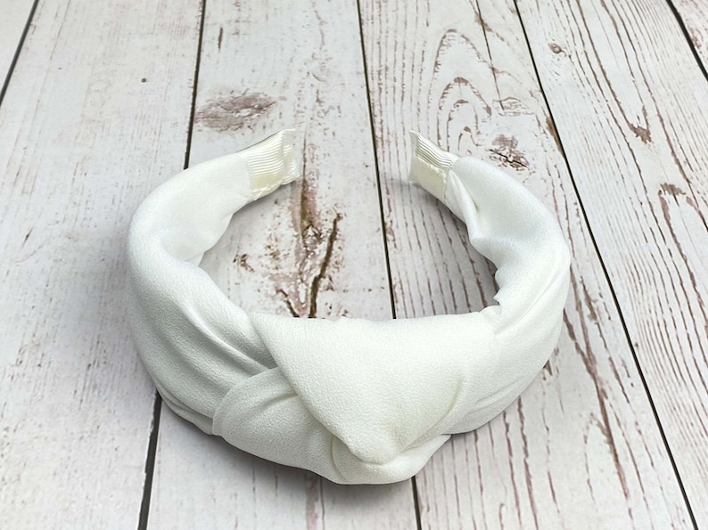 An elegant Snow White padded headband, featuring a chic design perfect for weddings and celebrations. The sophisticated hair accessory is made from high-quality materials, offering a touch of class and comfort for any occasion.