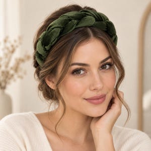 Woman wearing a dark olive green velvet braided headband with a wide padded design, styled with an elegant updo and cream knit top.