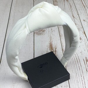 Perfect for brides, this white padded headband adds a touch of glamour to any outfit.