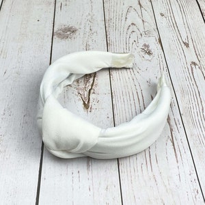 Make a statement at your next special event with this stylish white hairband.