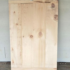 May include: A white ceramic mug with a black handle and the text "But First, Coffee" in a bold, black font. The mug is set against a blurred background, suggesting a cozy setting.