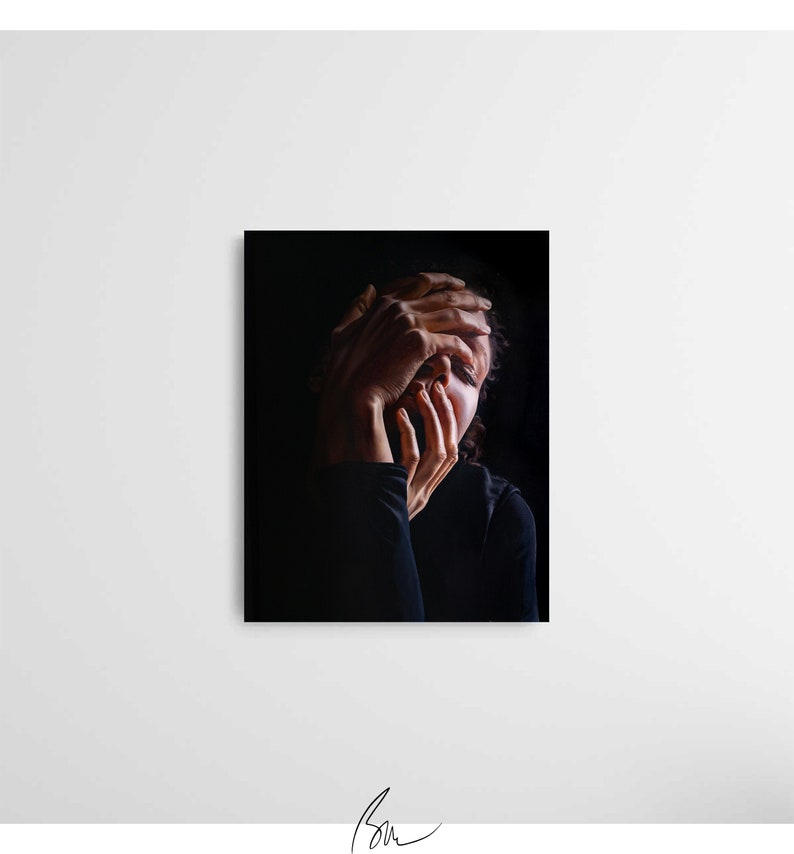 May include: A person with dark hair is shown in a close-up portrait. Their hands are covering their face, with only their eyes visible. The background is black.