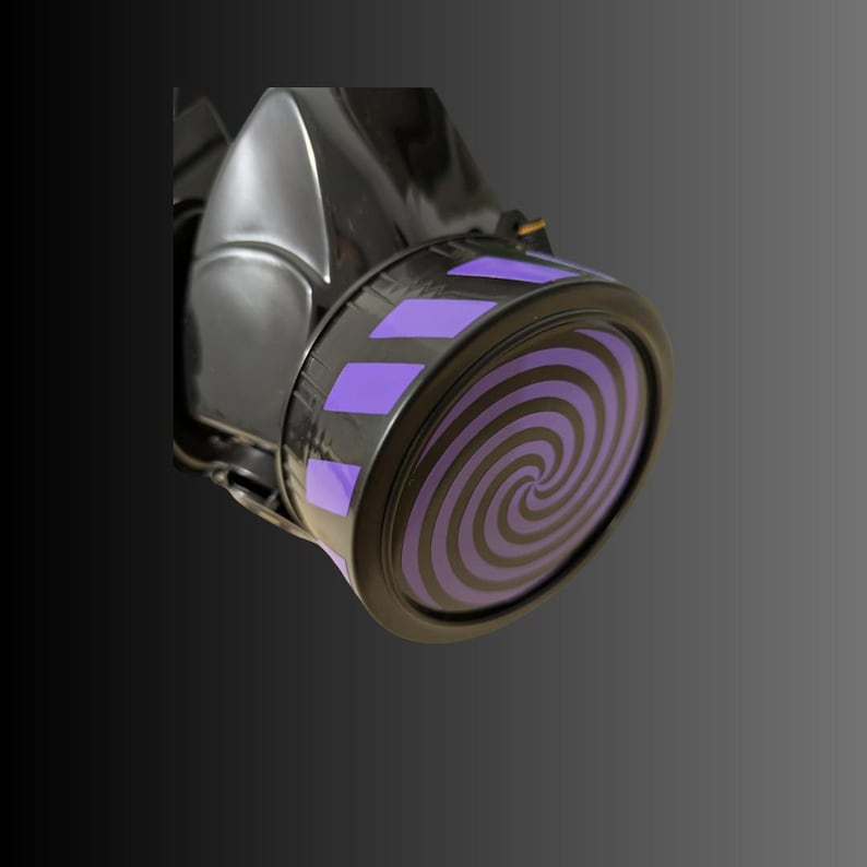 Pu&ograve; includere: Maschera antigas nera con un design a spirale viola e nero sul filtro.
