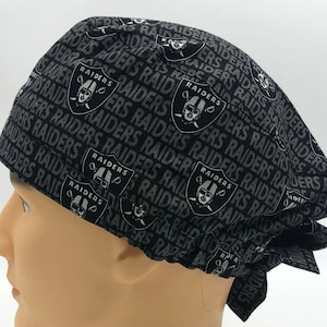 Könnte beinhalten: Schwarzer und weißer chirurgischer Scrubb-Hut mit einem sich wiederholenden Muster des Las Vegas Raiders-Logos und dem Wort "Raiders".