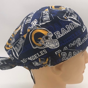Könnte beinhalten: Blau-gelbe OP-Mütze mit einem Los Angeles Rams Logo und den Worten "Rams" und "Los Angeles", die sich auf dem Stoff wiederholen.