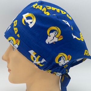 Könnte beinhalten: Eine blaue OP-Mütze mit einem gelben und weißen Muster des Logos der Los Angeles Rams und dem Wort "Rams".