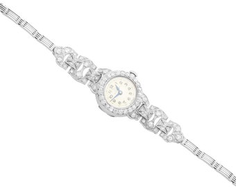 May include: A silver wristwatch with a white face and diamond-encrusted band.