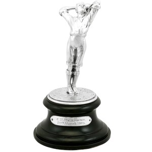 May include: Silver trophy of a golfer in a raised pose, standing on a black wooden base with a silver plaque that reads "C.N. BECKFORD 29th March 1925."