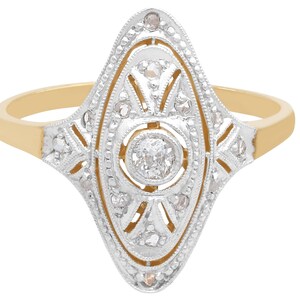 May include: A gold and silver ring with a large, round diamond in the center. The diamond is surrounded by smaller diamonds in a geometric pattern.