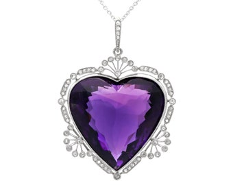 May include: A silver heart-shaped pendant necklace featuring a large purple amethyst gemstone surrounded by smaller diamonds.