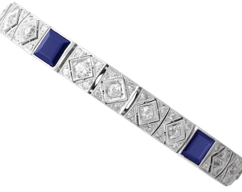 Puede incluir: Una pulsera de eslabones en tono plateado que presenta una alternancia de piedras rectangulares de color azul profundo y piedras claras engastadas en cuadrado. El diseño incluye marcos metálicos geométricos alrededor de cada piedra.