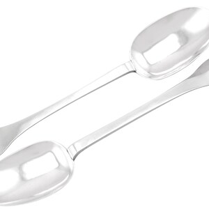 May include: Two silver serving spoons with heart-shaped handles. The spoons have a polished finish and are in excellent condition.