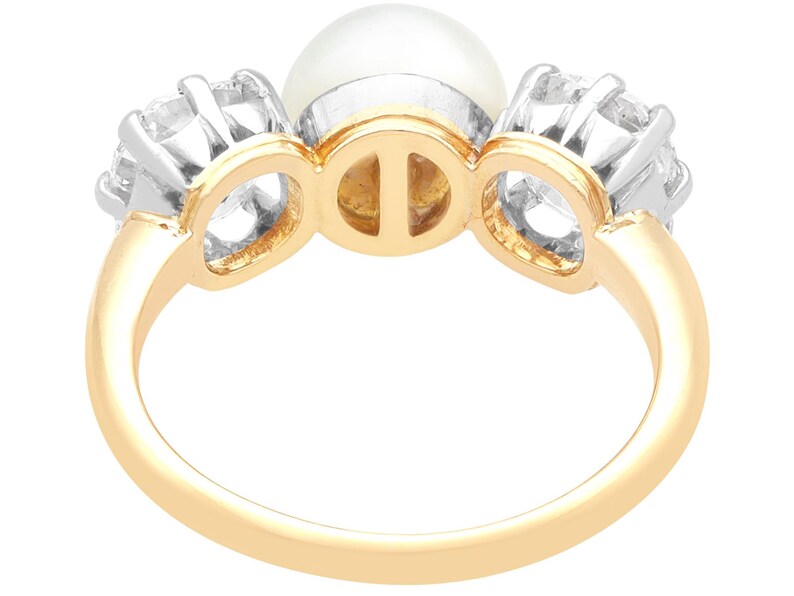 May include: A gold ring with a pearl and two diamonds. The ring is set in a three-prong setting.