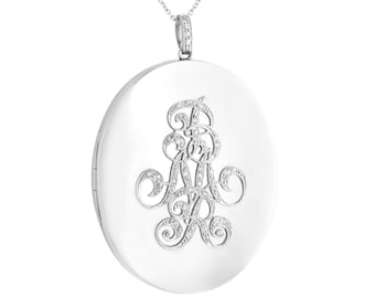 Op de afbeelding: Zilveren ovaal medaillon met een monogram bezet met diamanten.