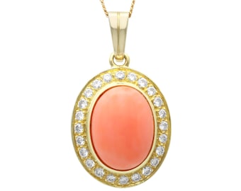 Op de afbeelding: Een gouden ketting met een hanger met een grote ovale koraalsteen omringd door een halo van kleine diamanten.