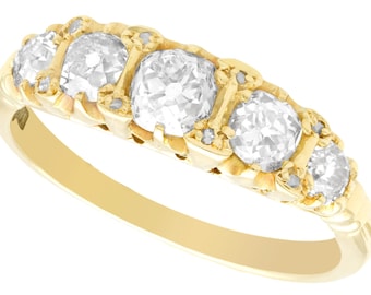 May include: A gold band ring with five round clear diamonds set in a decorative design.