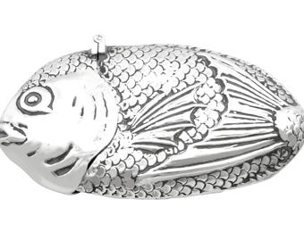 Könnte beinhalten: Eine silberne Fisch-Box mit detaillierten Schuppen und Flossen. Die Box hat einen Klappdeckel und einen kleinen Griff oben. Das Design ist sehr detailliert, mit poliertem Finish. Wahrscheinlich ein dekorativer Artikel oder ein Behälter für kleine Gegenstände.