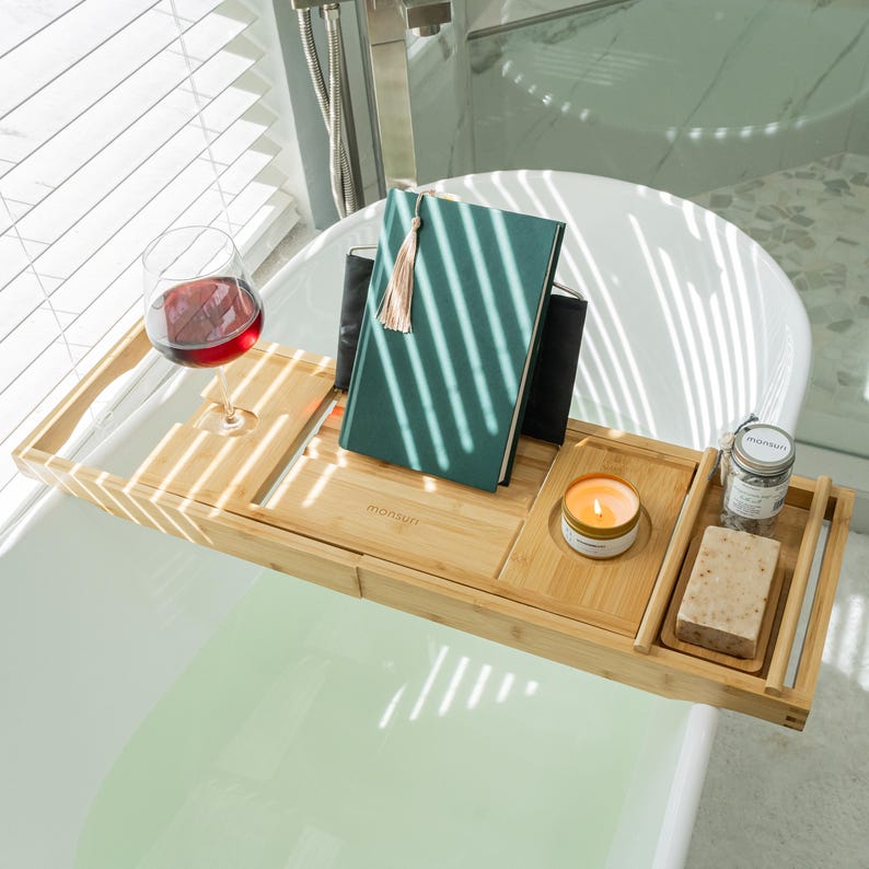 Bath pillow and bathtub tray set, the tray: a book on the stand, red wine in the slide-in glass slot, a small candle in the round recess, and a jar of bath salts with a bar of soap on the removable dish.