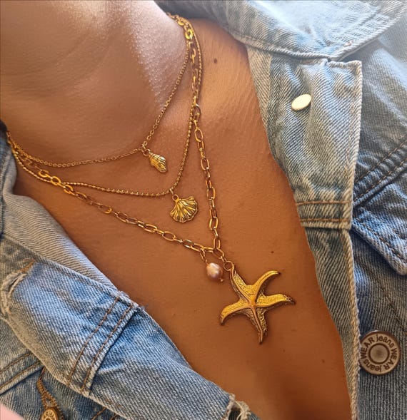 Gold-tone triple-strand stainless steel chain necklace (304L) with starfish, seashell, and pink pearl pendants. Anne Cé's jewelry.