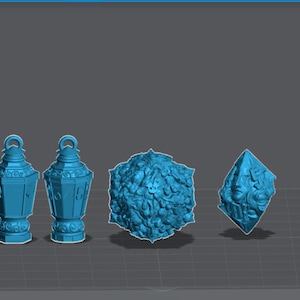 Może przedstawiać: Trzy niebieskie, trójwymiarowe przedmioty dekoracyjne, wydrukowane w technologii 3D. Dwa to ozdobne lampiony o geometrycznym wzorze, a trzeci to sześcian z bogatym wzorem kwiatowym.